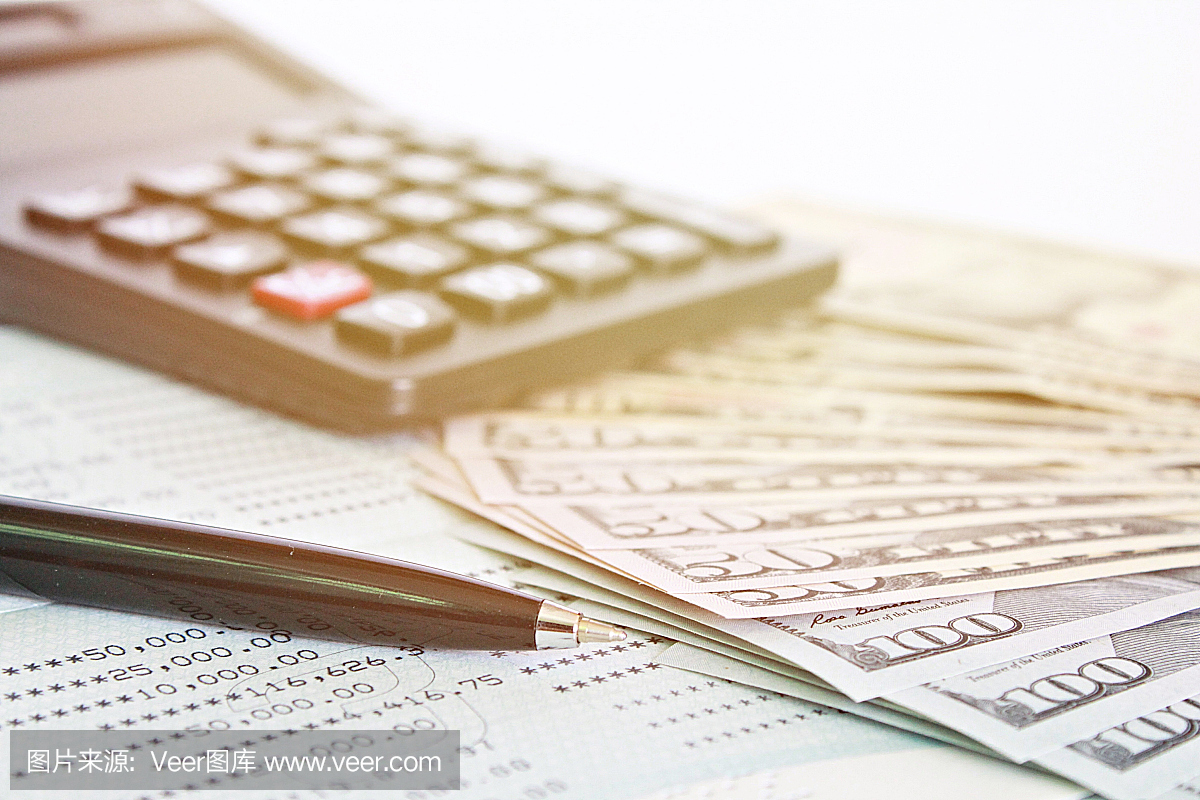 美元现金,桌子上的计算器和储蓄账户存折或财