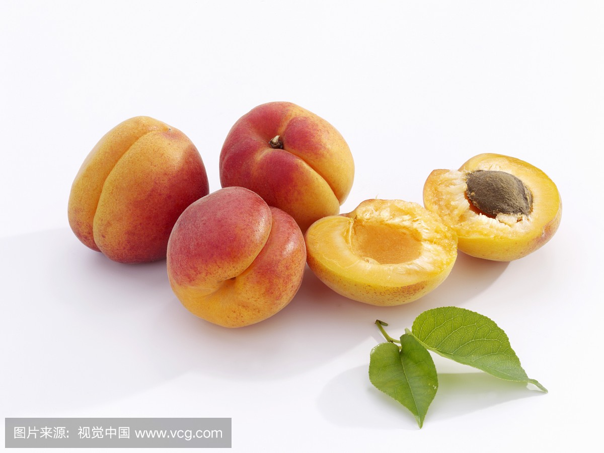 A few apricots with leaves, whole and halved
