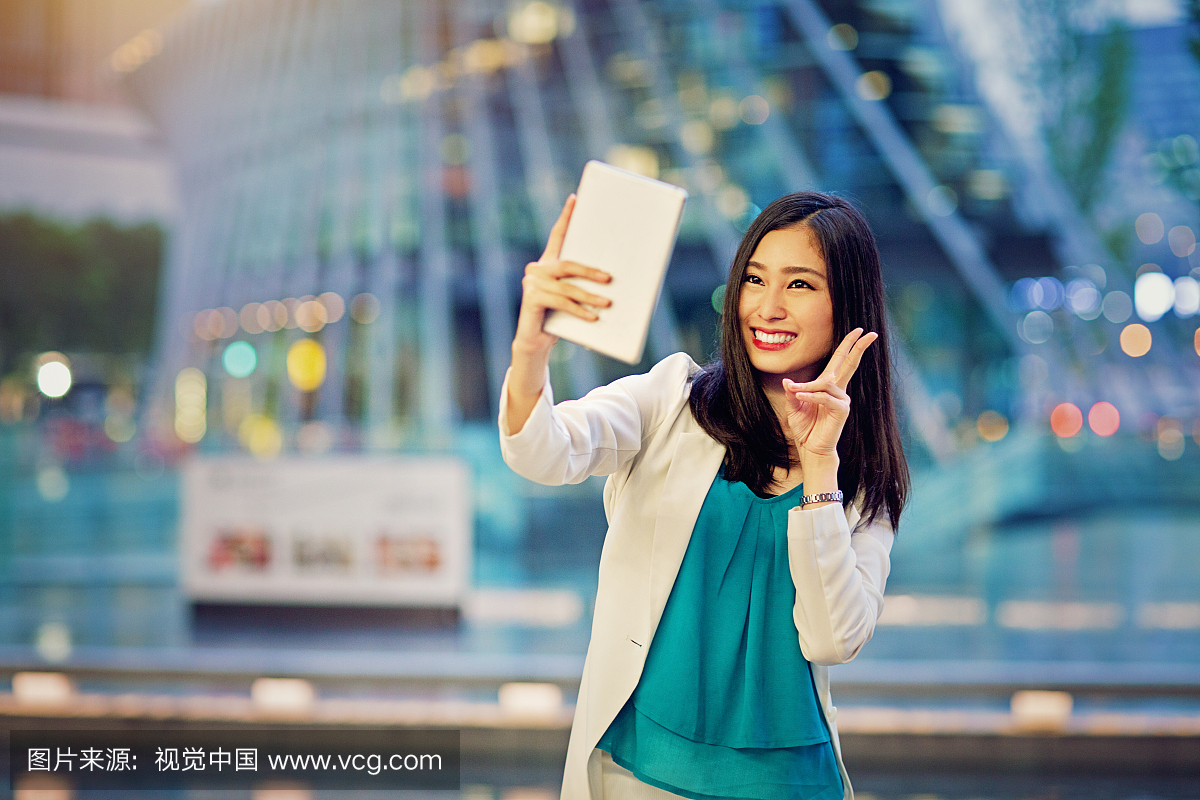 年轻的日本女人正在使用她的数字平板电脑采取