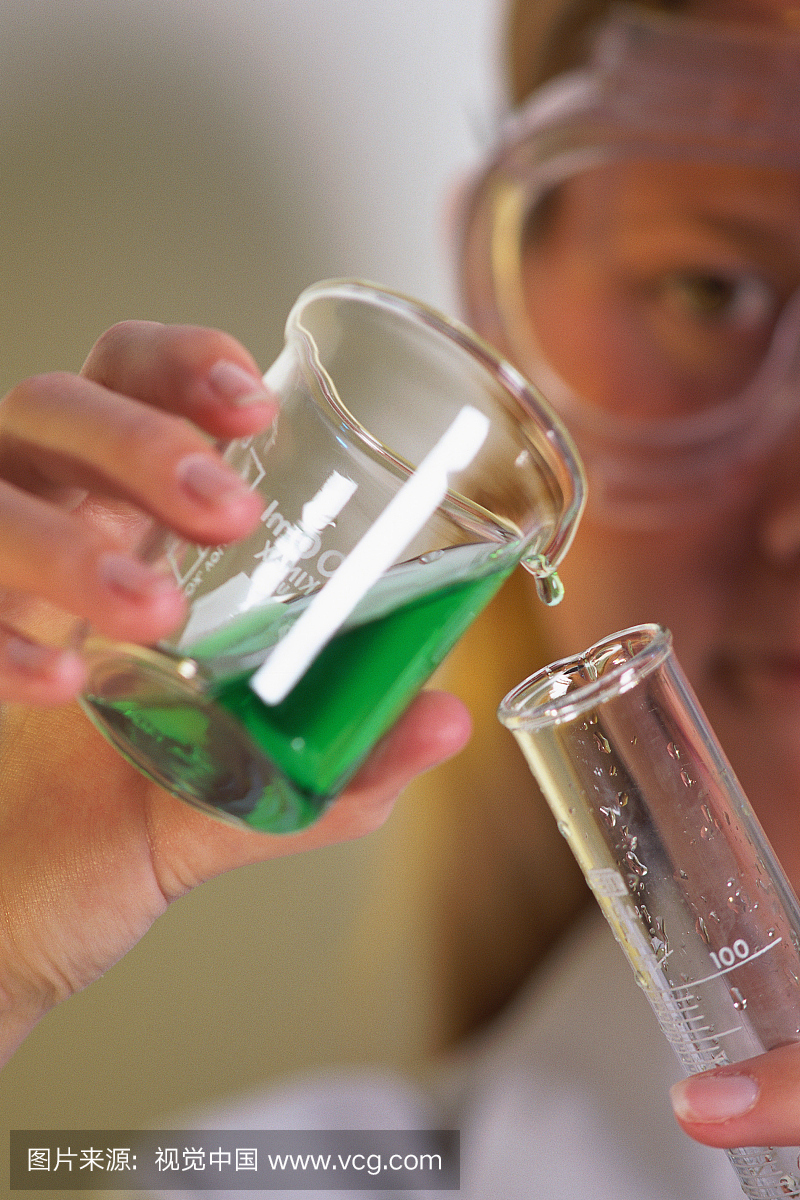 实验室技术人员将液体从烧杯倒入玻璃管中