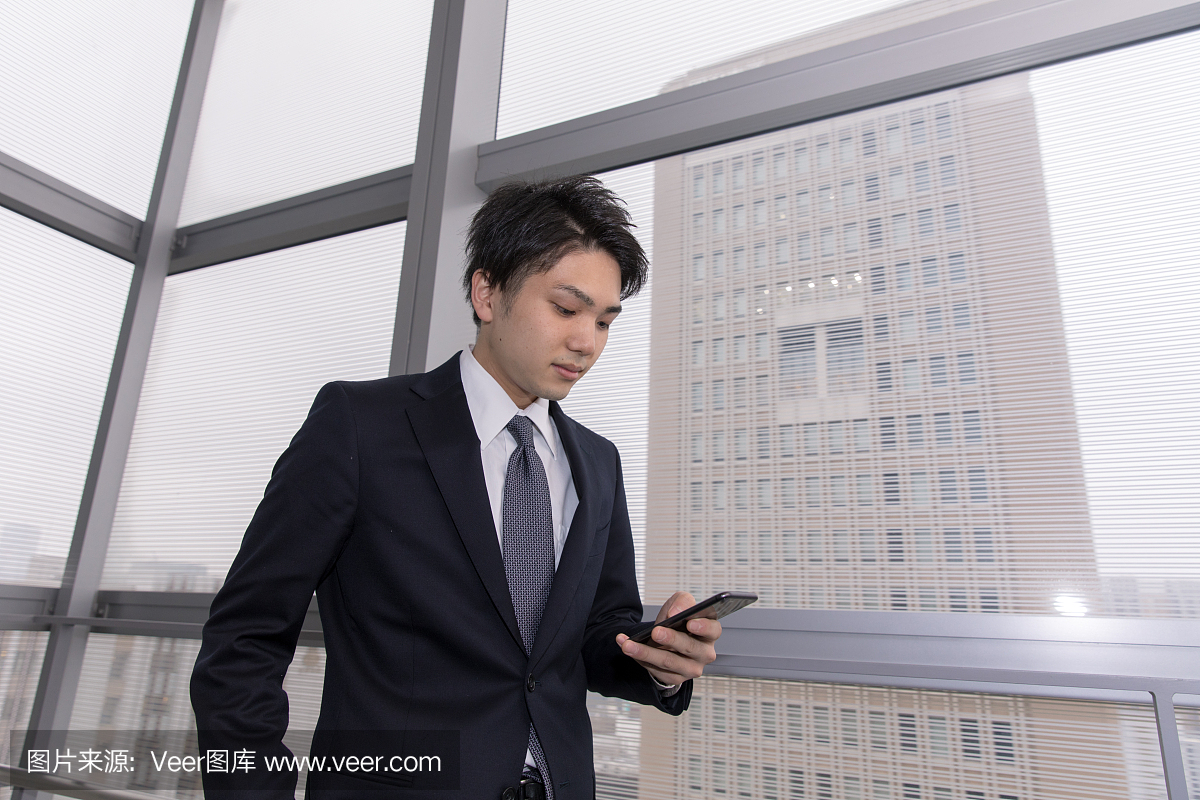 Young businessman texting on smart phone nea