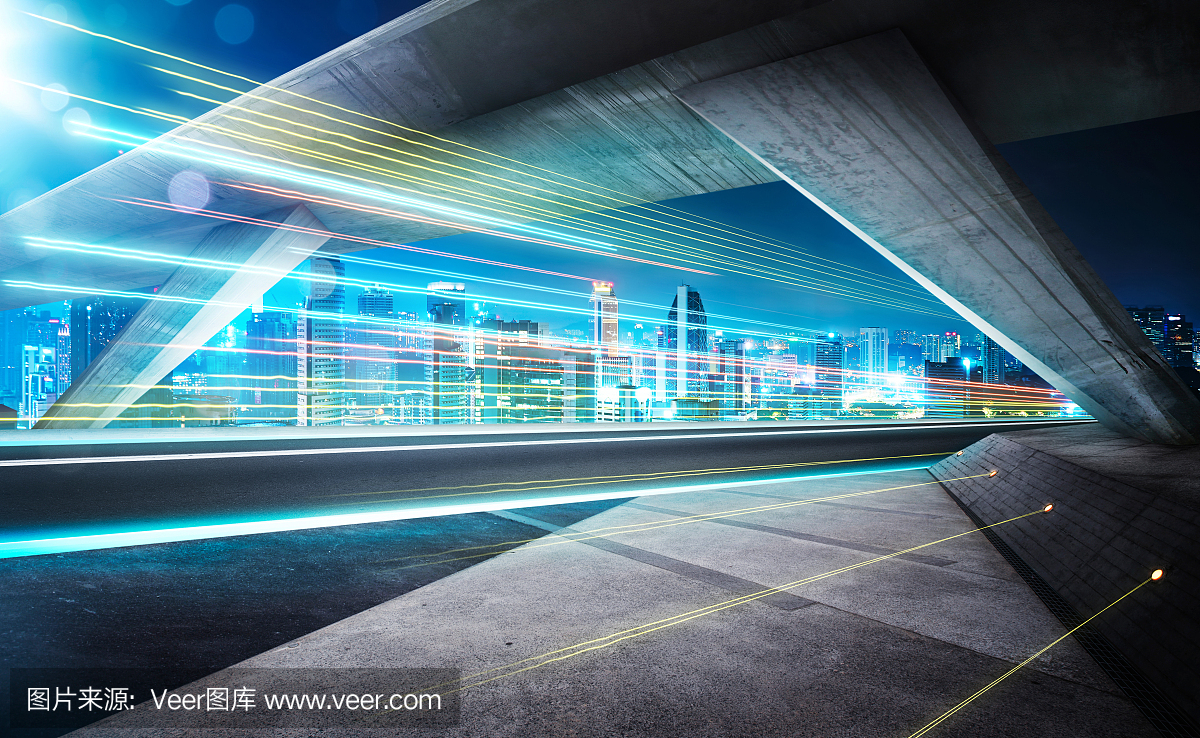 在与光径和美丽的城市天际线背景夜间桥下的空