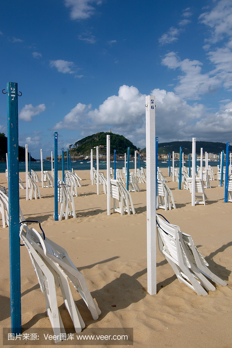 在西班牙圣塞巴斯蒂安海滩的伞和椅子