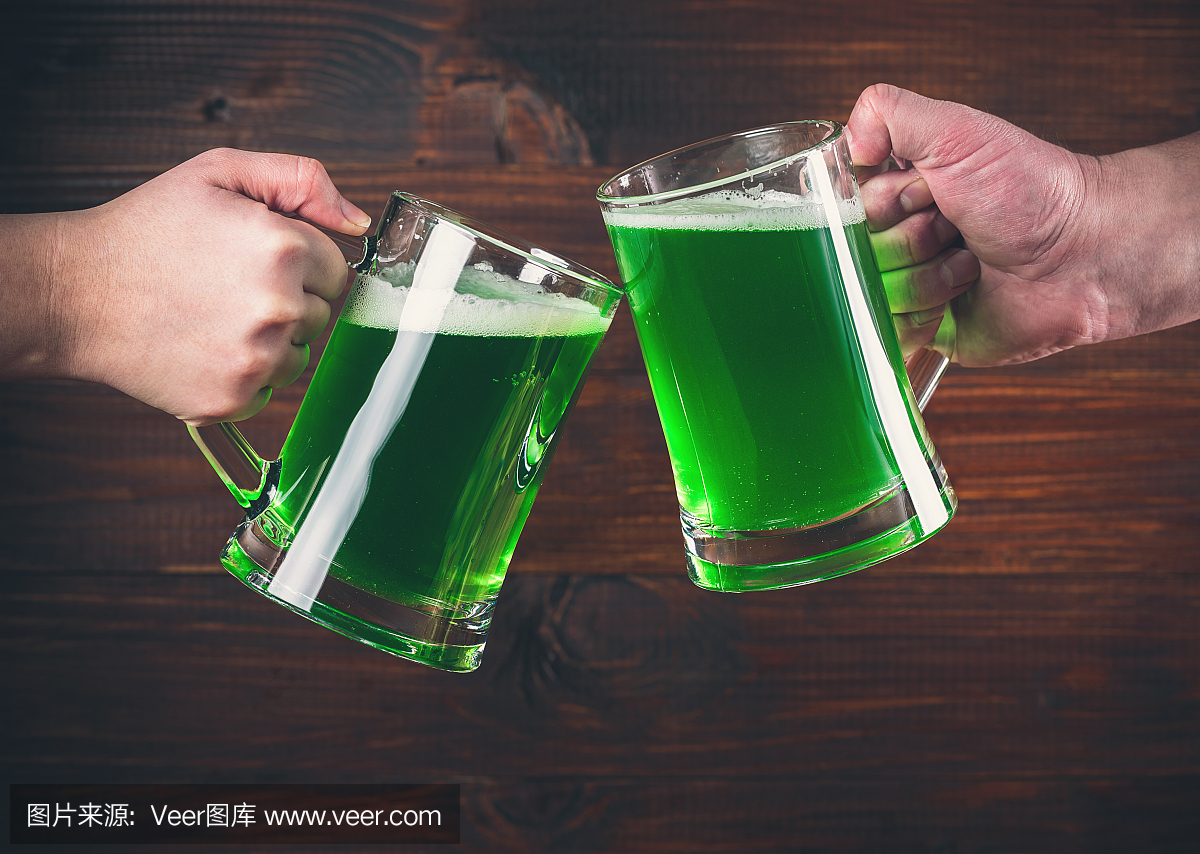 圣帕特里克节概念两杯手上绿色啤酒反对木背景