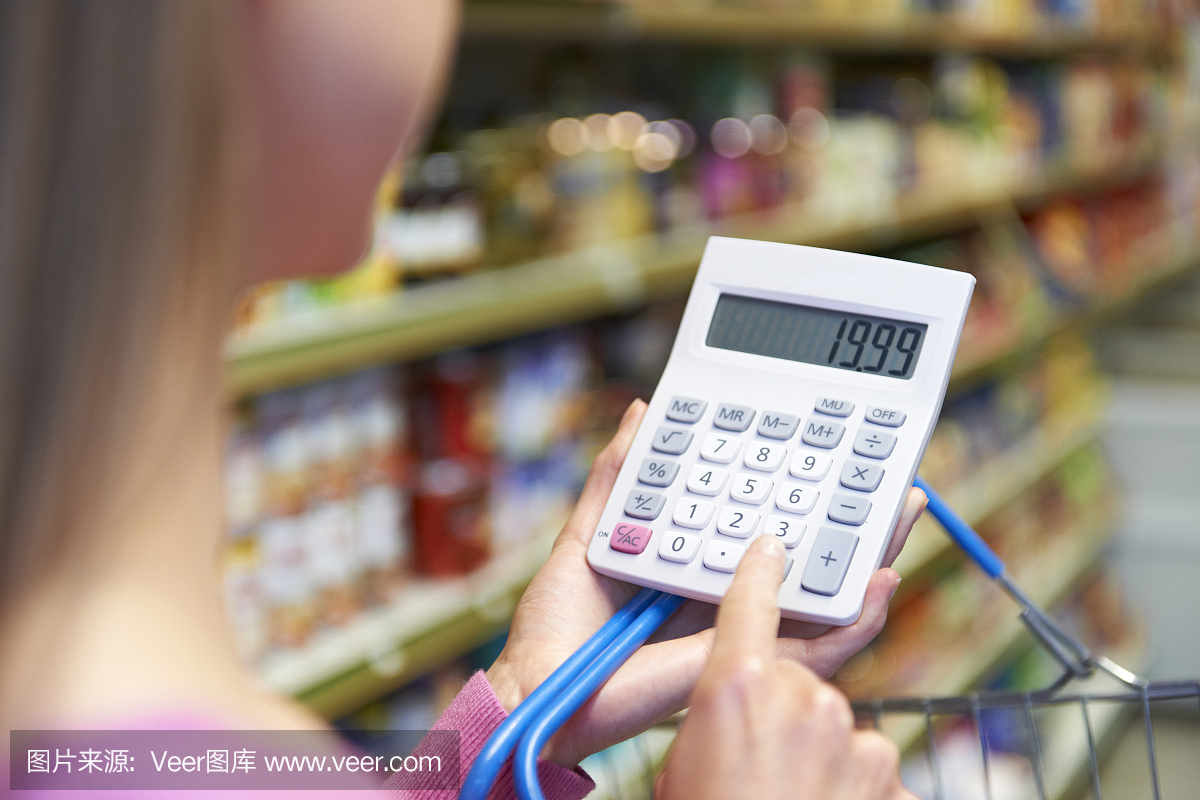 女人使用计算器成本超市购物