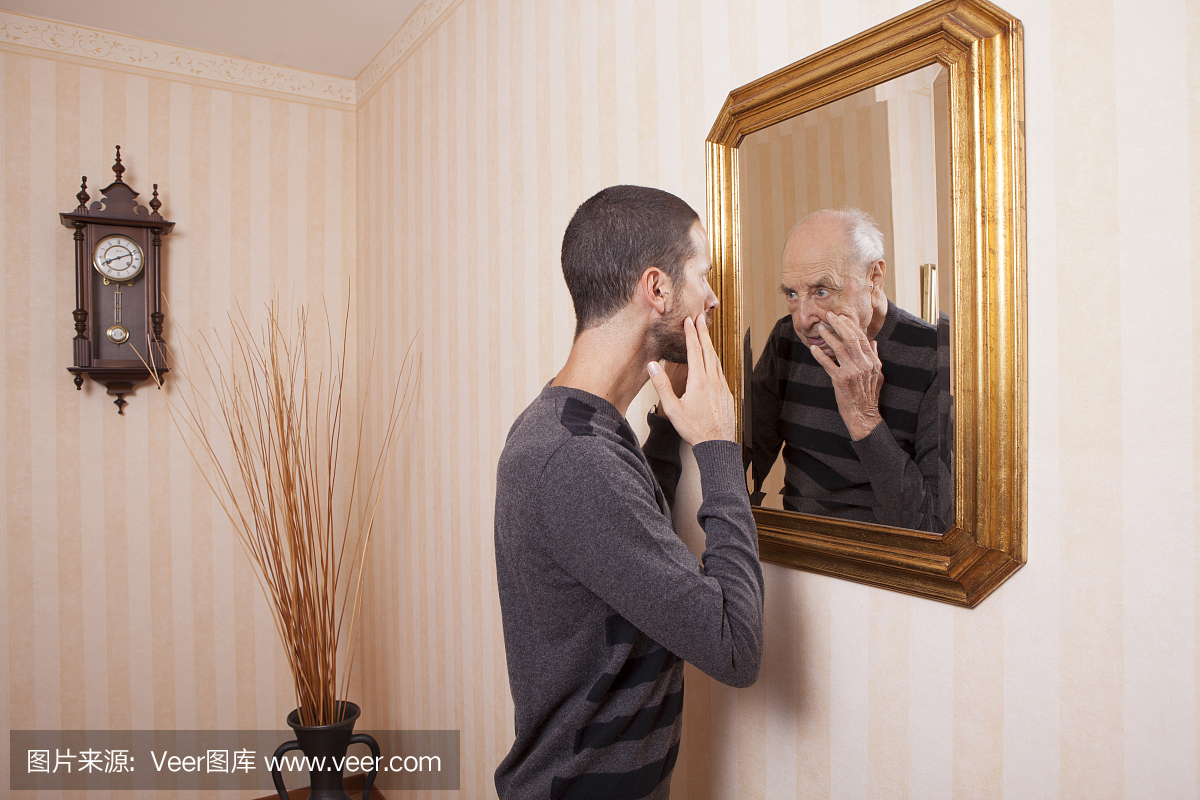 年轻人在镜子里看着老年人