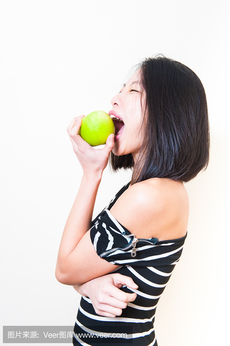 年轻美丽的亚裔女人咬绿色苹果配置文件