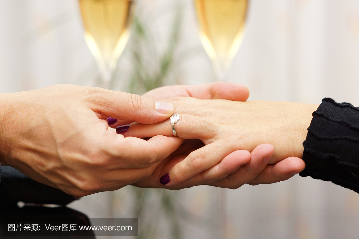 男人把订婚戒指放在他未婚夫的手指上
