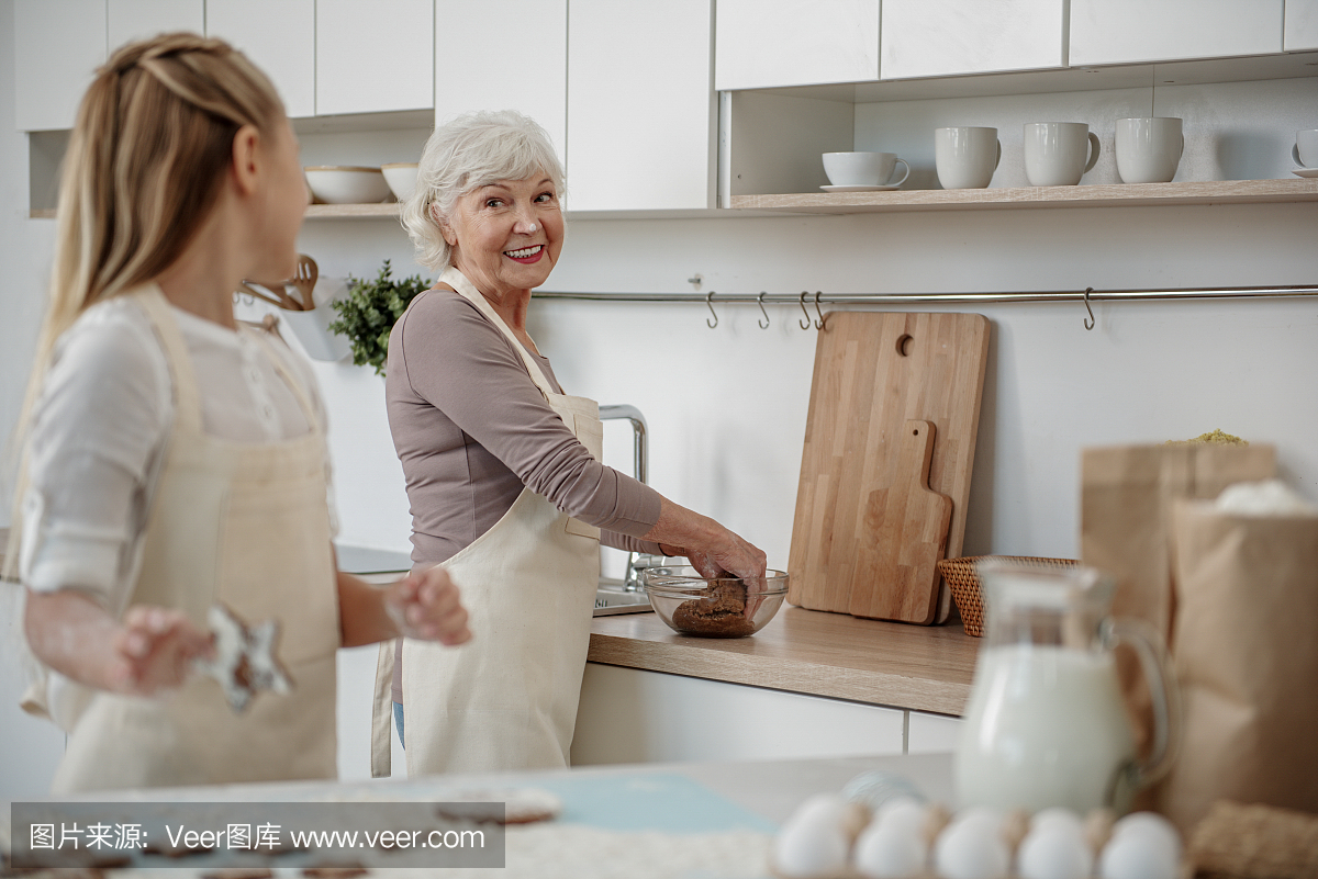 快乐的奶奶与她的孙女在厨房里做糕点