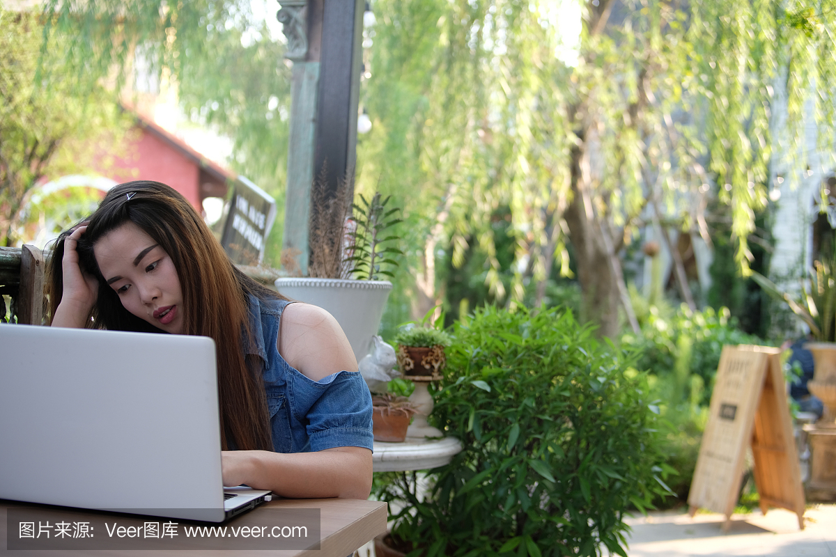 女人用笔记本电脑在棕色,咖啡厅,经营理念的木