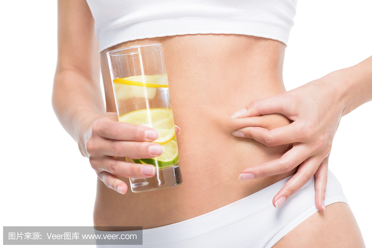 拿着杯水和夹在白色隔离的胃的妇女的部分视图
