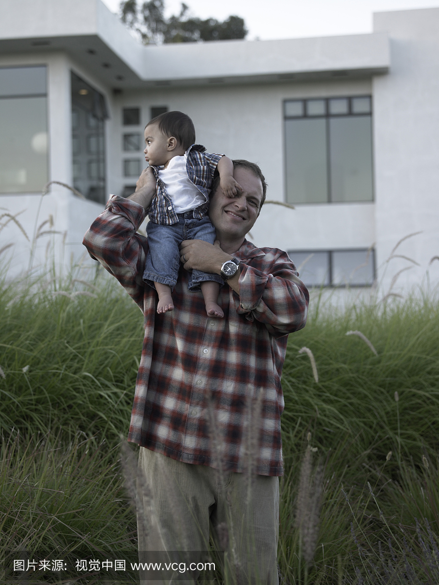 父亲与男婴(9-12个月)站在高大的草地