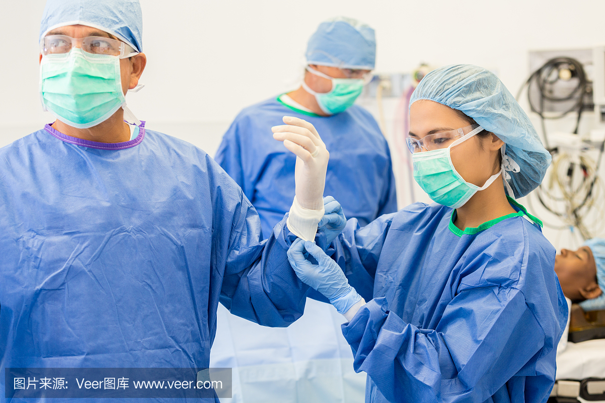 手术护士协助外科医生戴上手套和礼服
