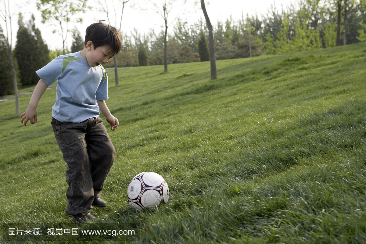 小男孩在公园踢足球