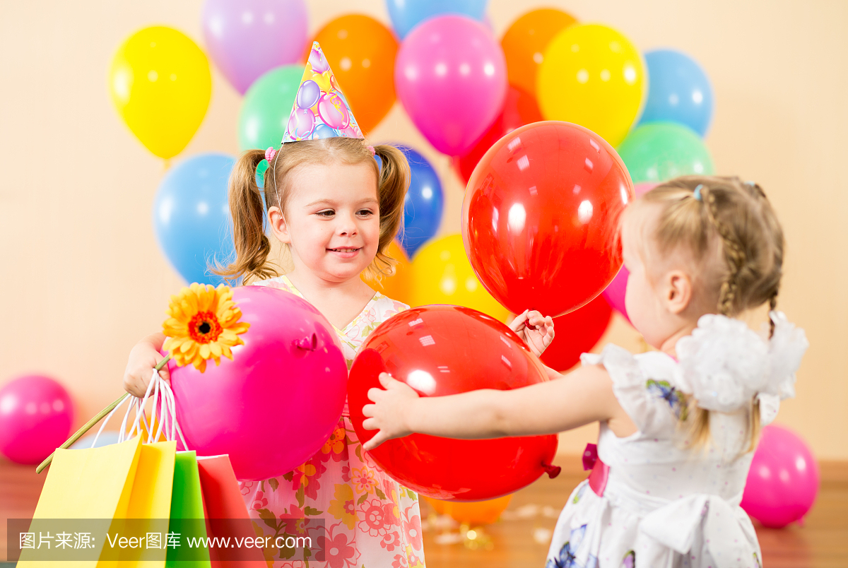 漂亮的孩子与生日礼物的五颜六色的气球和礼物
