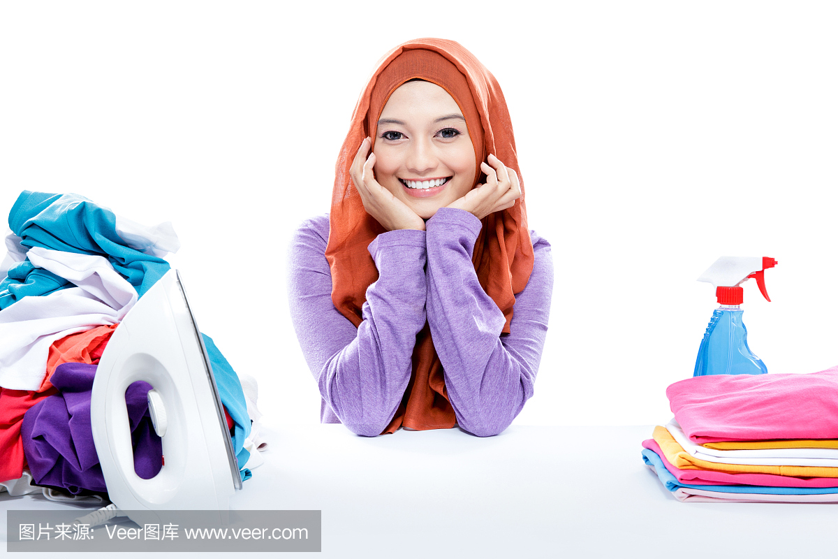 年轻微笑的女人戴着头巾坐在清洁的洗衣房之间
