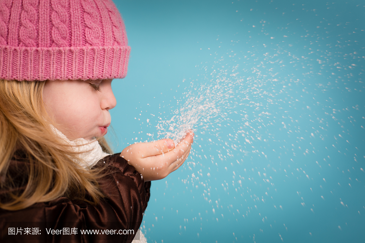 小女孩闭上眼睛,吹几杯雪