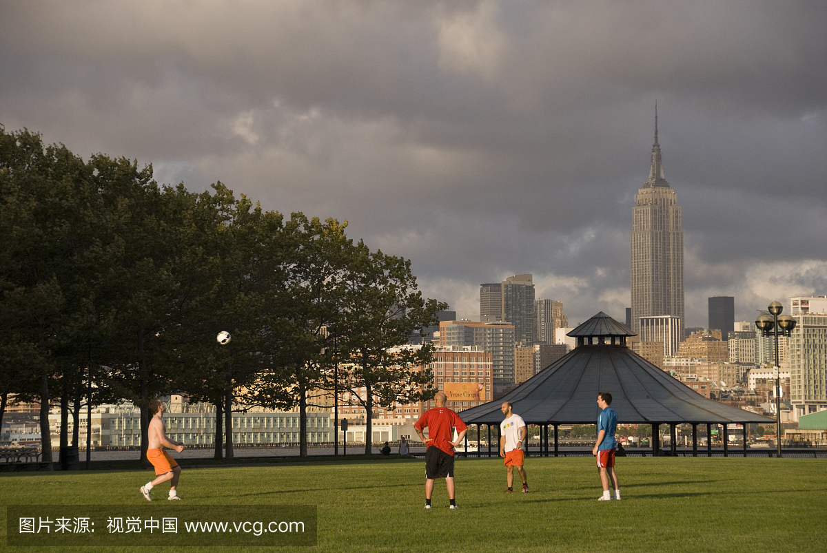 人们在曼哈顿天际线的码头A公园踢足球(足球)