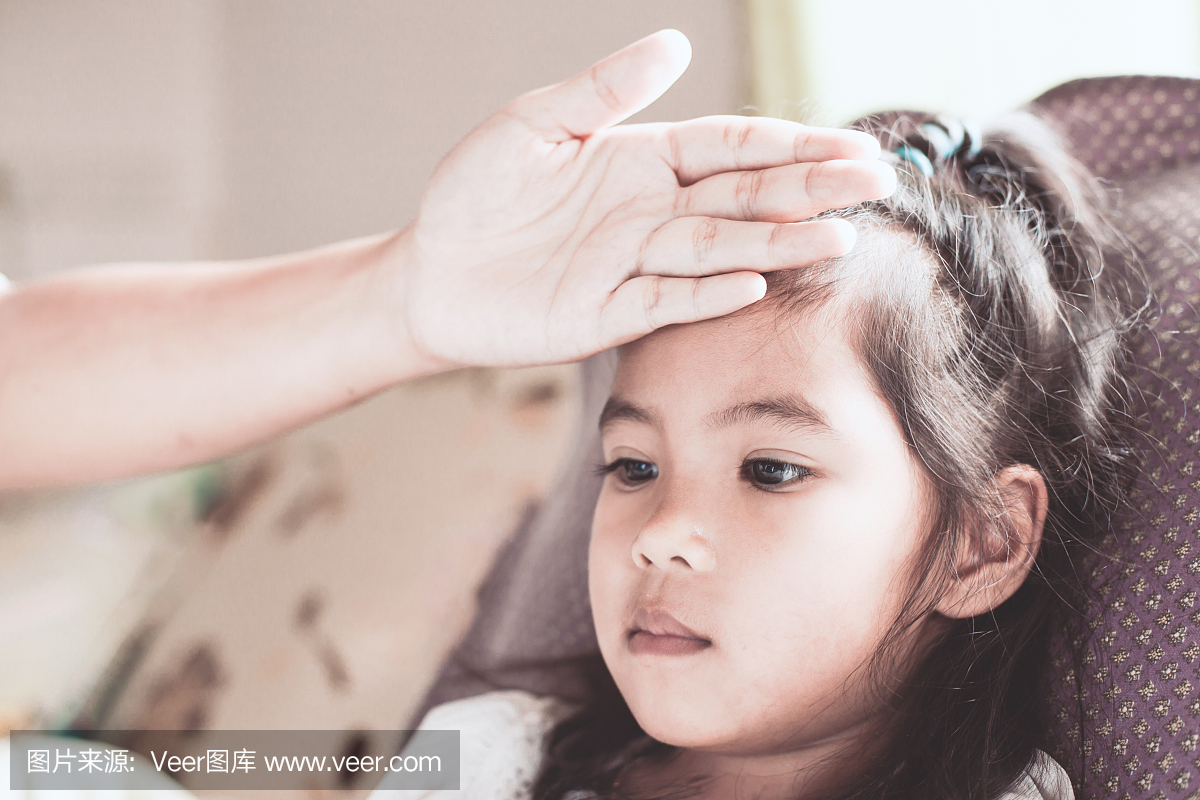 可爱的亚洲孩子女孩病和母亲的手触摸她的额头