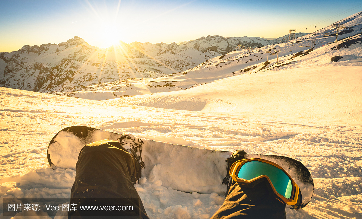 Snowboarder sitting on relax moment at sunset