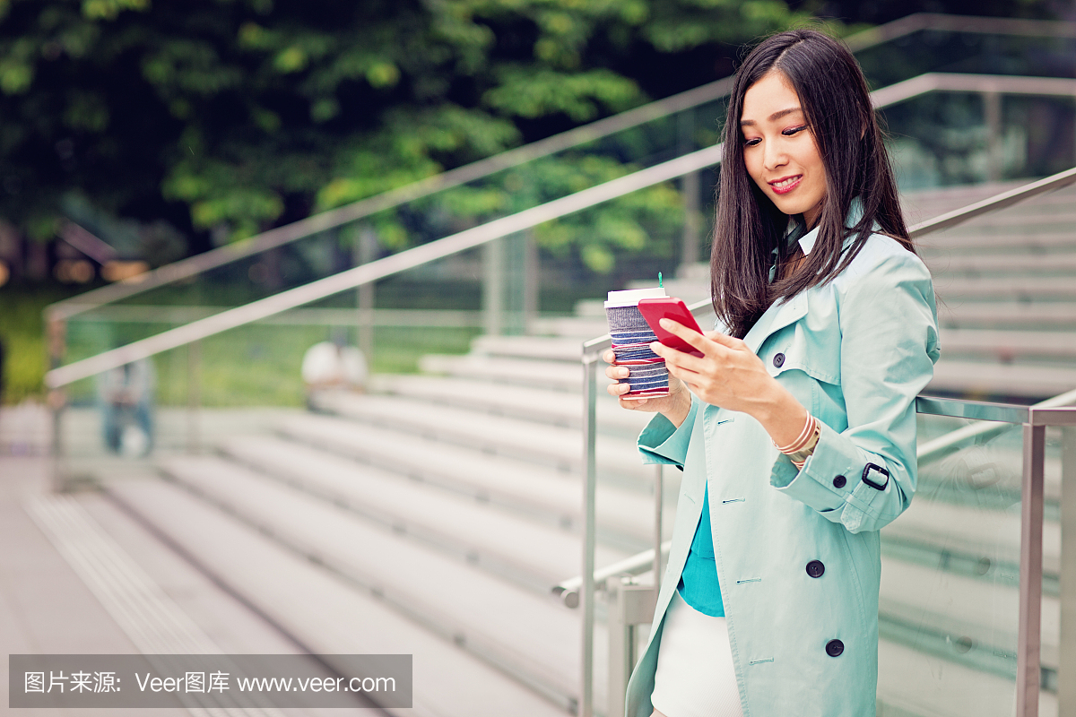 年轻的日本女人正在和她的手机发短信