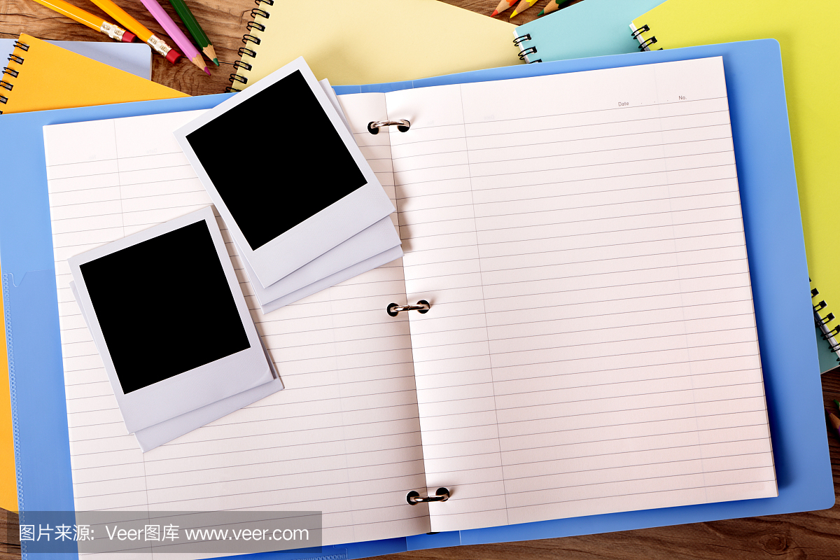 学生桌上有蓝色项目文件夹和空白照片。