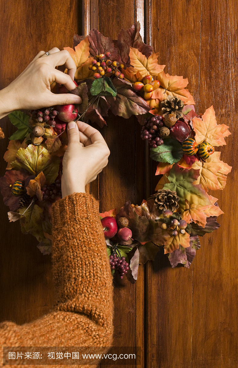 手安置秋天的花圈挂在木门上,蒙特利尔,魁北克