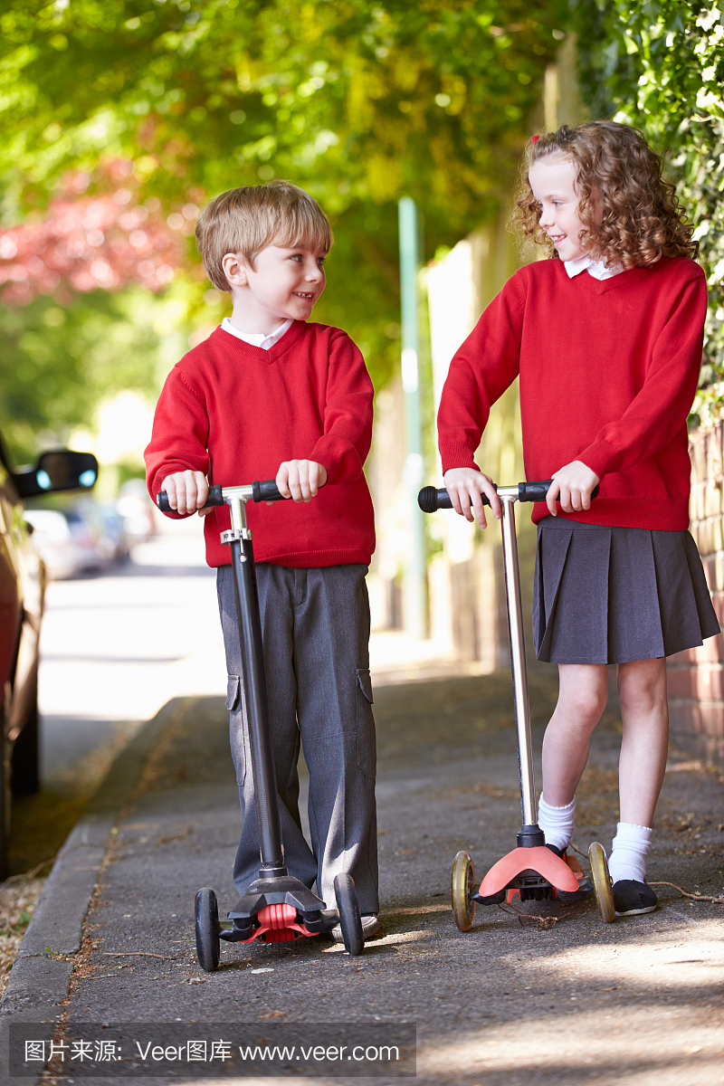 男孩和女孩骑着滑板车上路上学