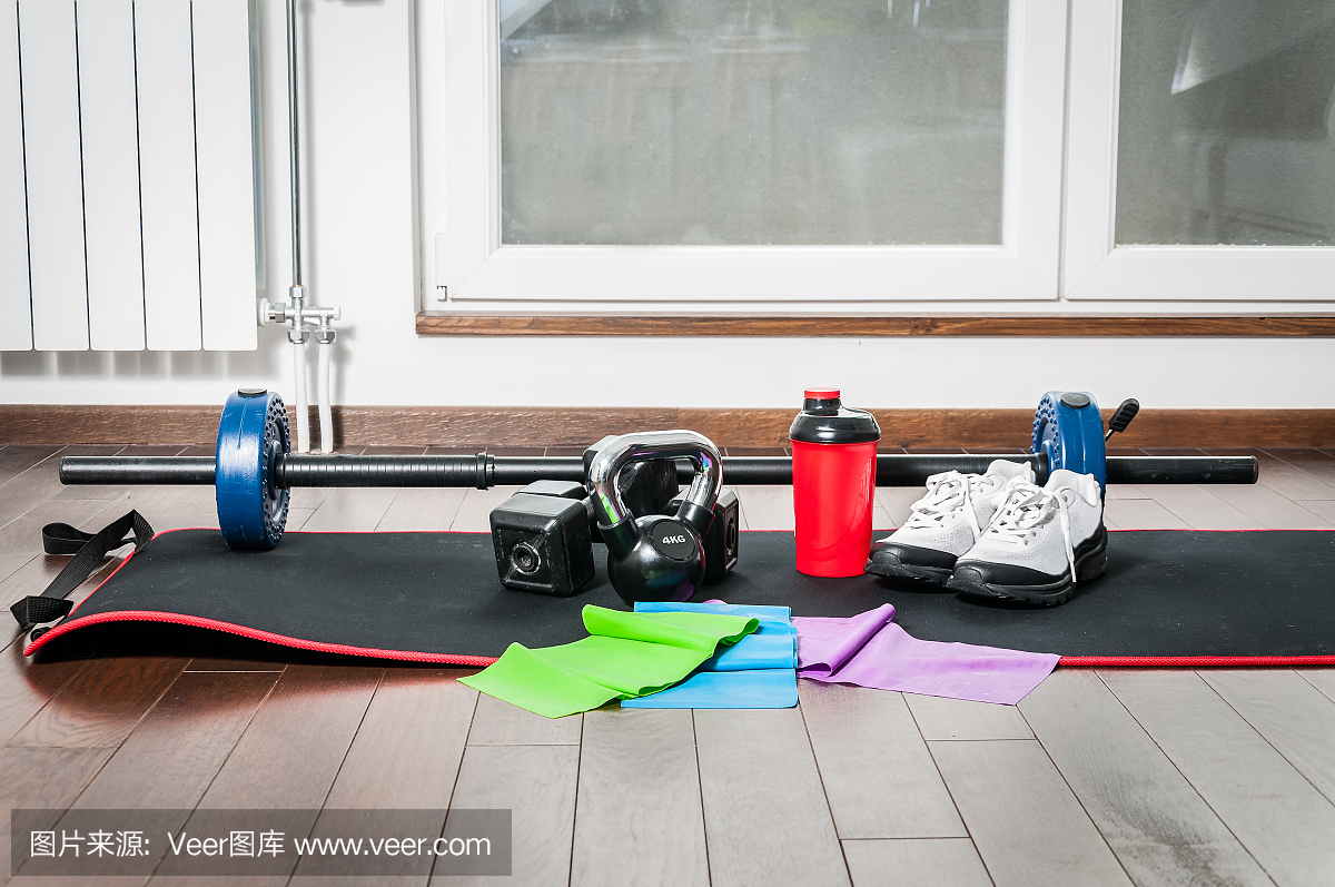 健身运动器材。家庭公寓地板上的女人健身器材