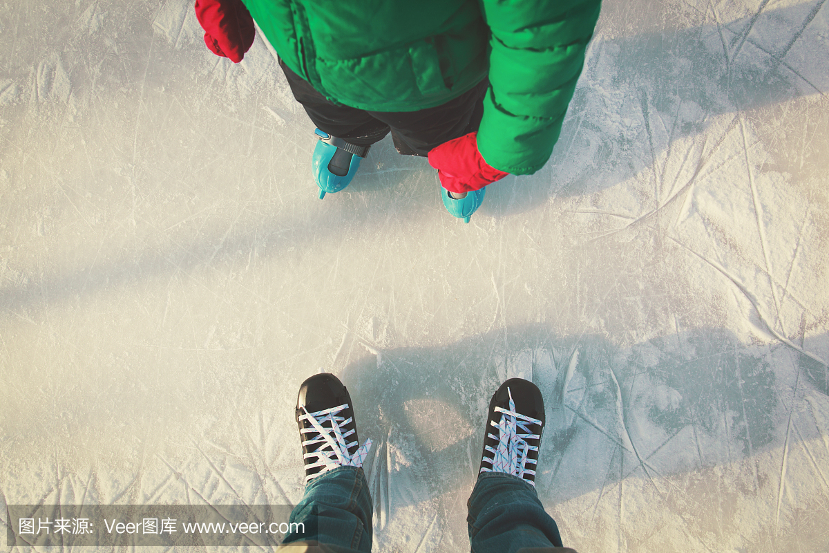 父亲和孩子在冬天学习滑冰