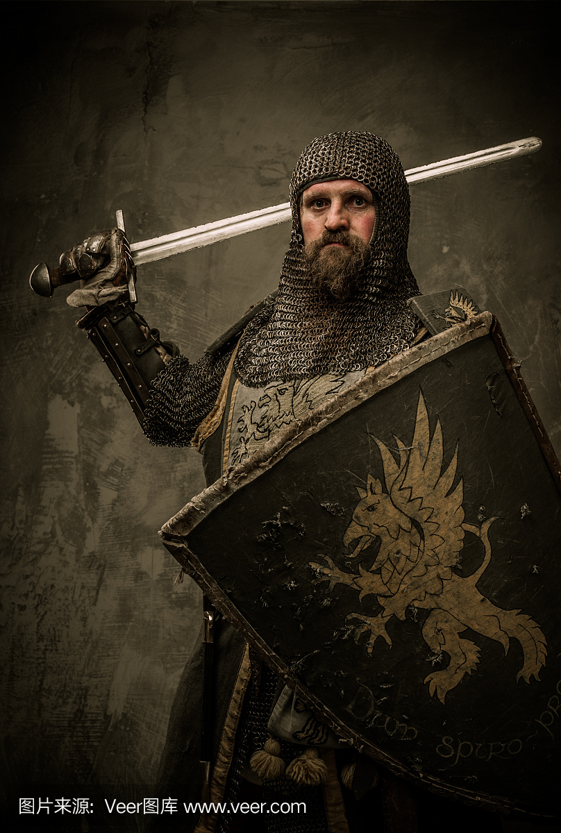 中世纪骑士与剑和盾牌对石墙