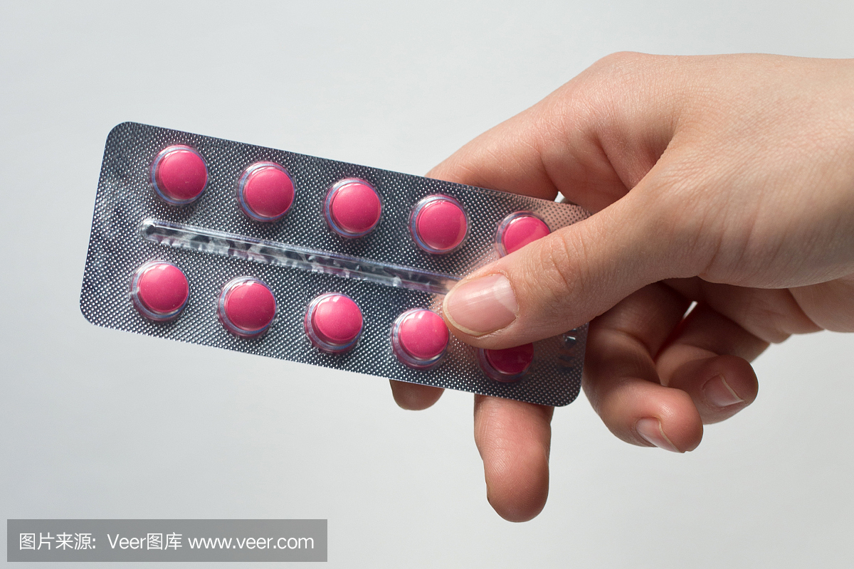 女人手持药物 - 红色药片的全银片通常片剂形状