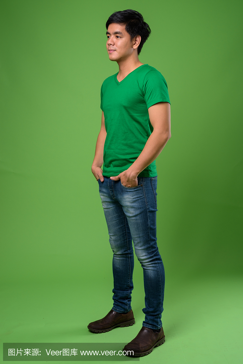 工作室拍摄的年轻英俊的菲律宾人反对绿色背景