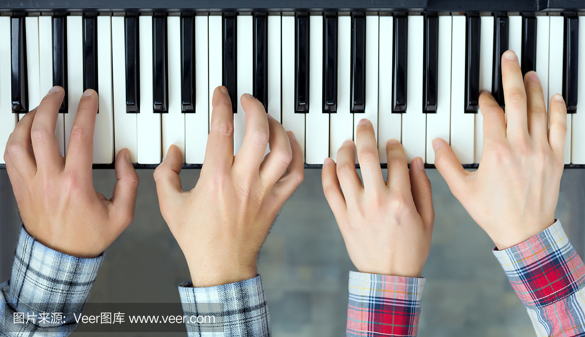 钢琴键盘顶部查看男人和女人玩的手