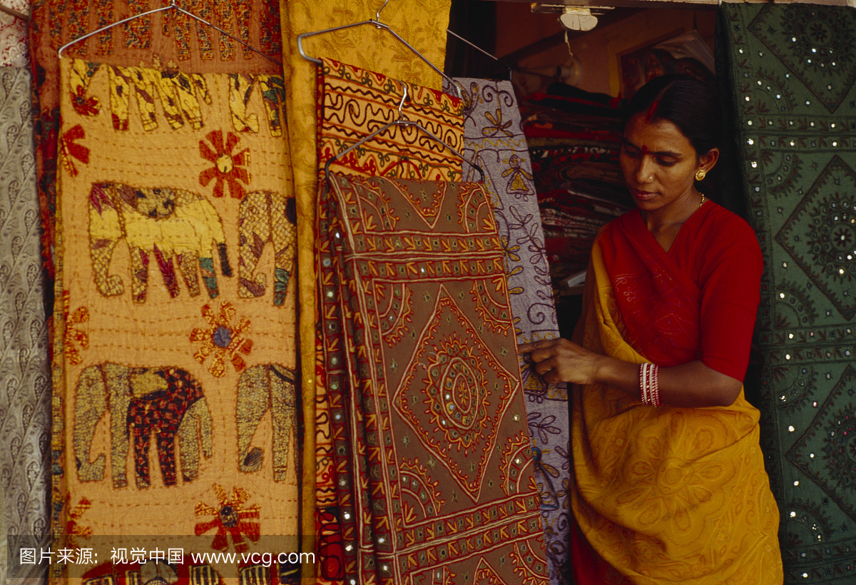 新德里,印度。一个女人看着传统的印度面料,有