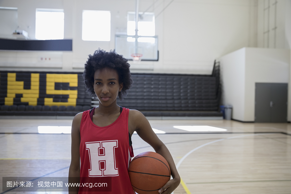 肖像自信的女子篮球运动员在体育馆