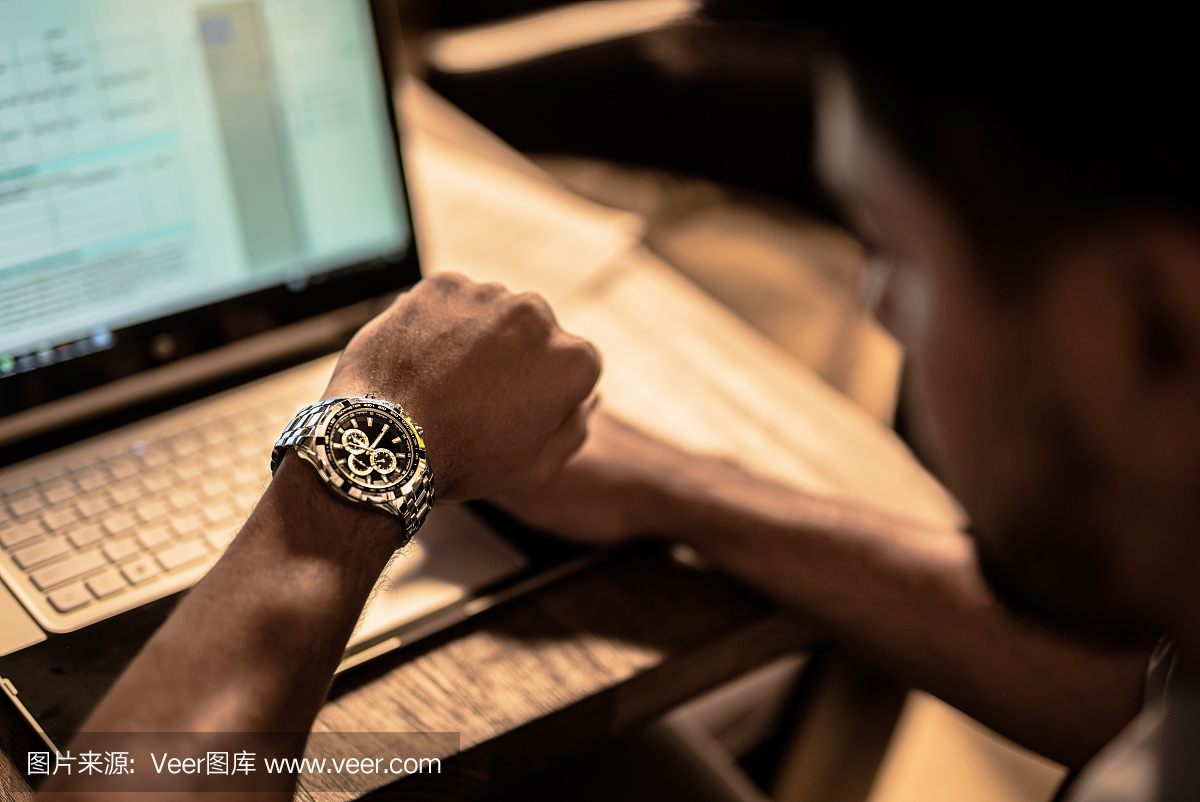 年轻的非洲裔美国商人工作到深夜和检查时间。