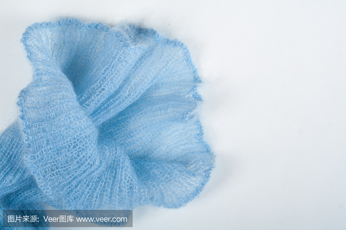 编织马海毛羊毛和针织手工制作在木桌上。蓝花