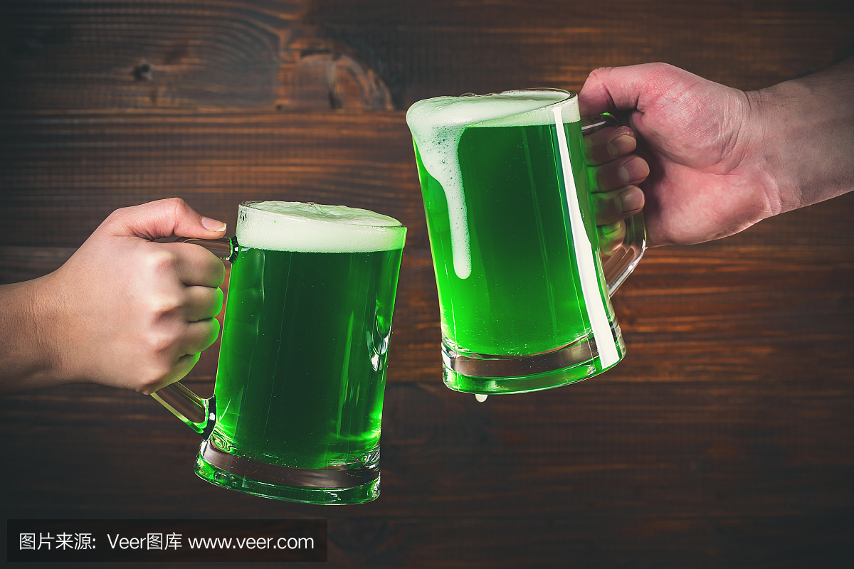 圣帕特里克节概念两杯手上绿色啤酒反对木背景