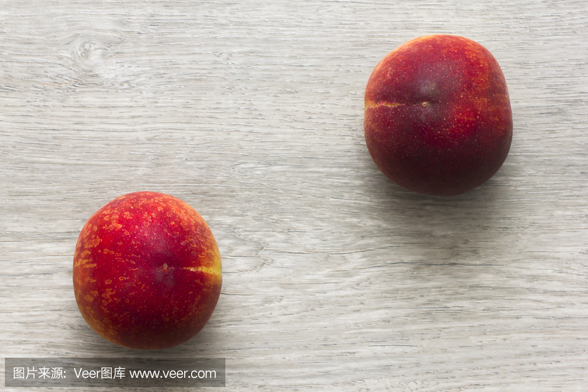 两个桃子在木桌上。直接在上面。