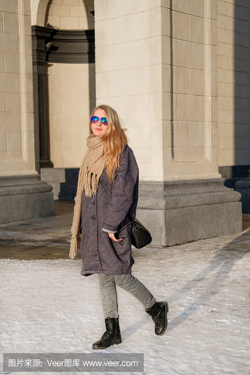 城市的背景。一个灰色温暖的外套,针织围巾和