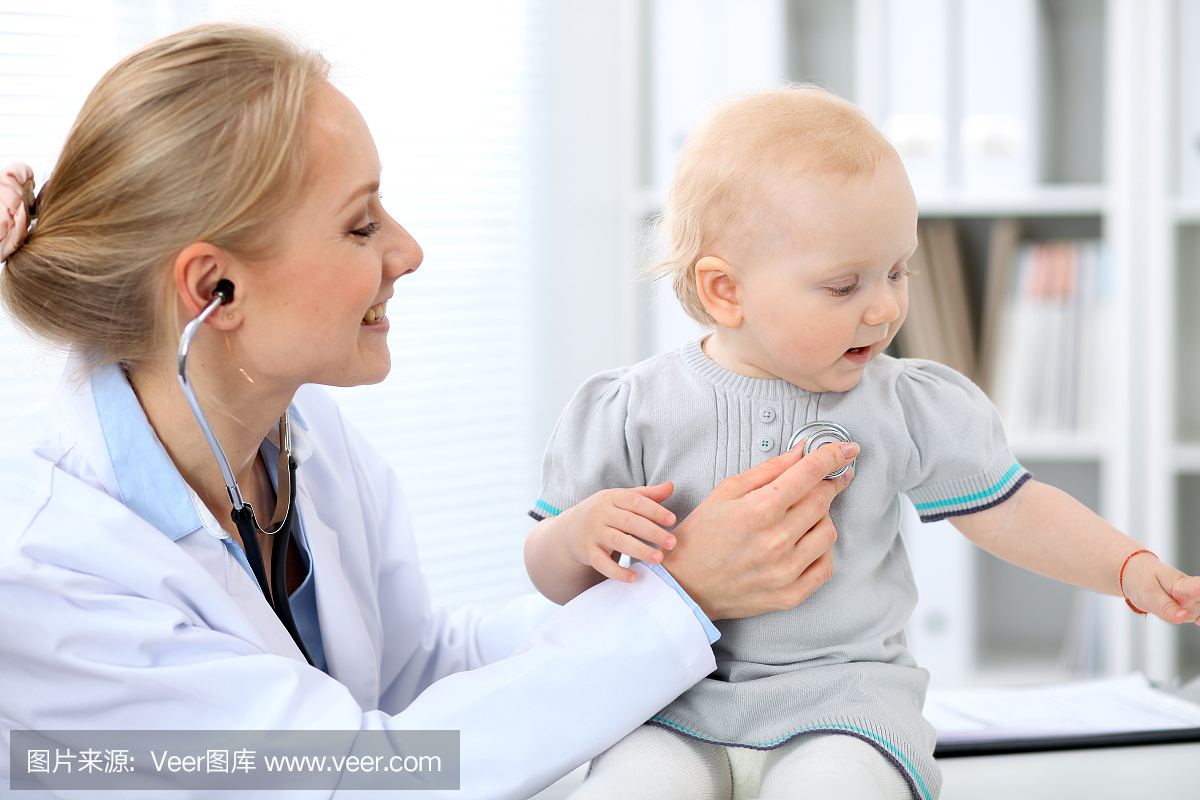 儿科医生正在医院照顾宝宝。小女孩被医生用听诊器检查。保健，保险和帮助理念。