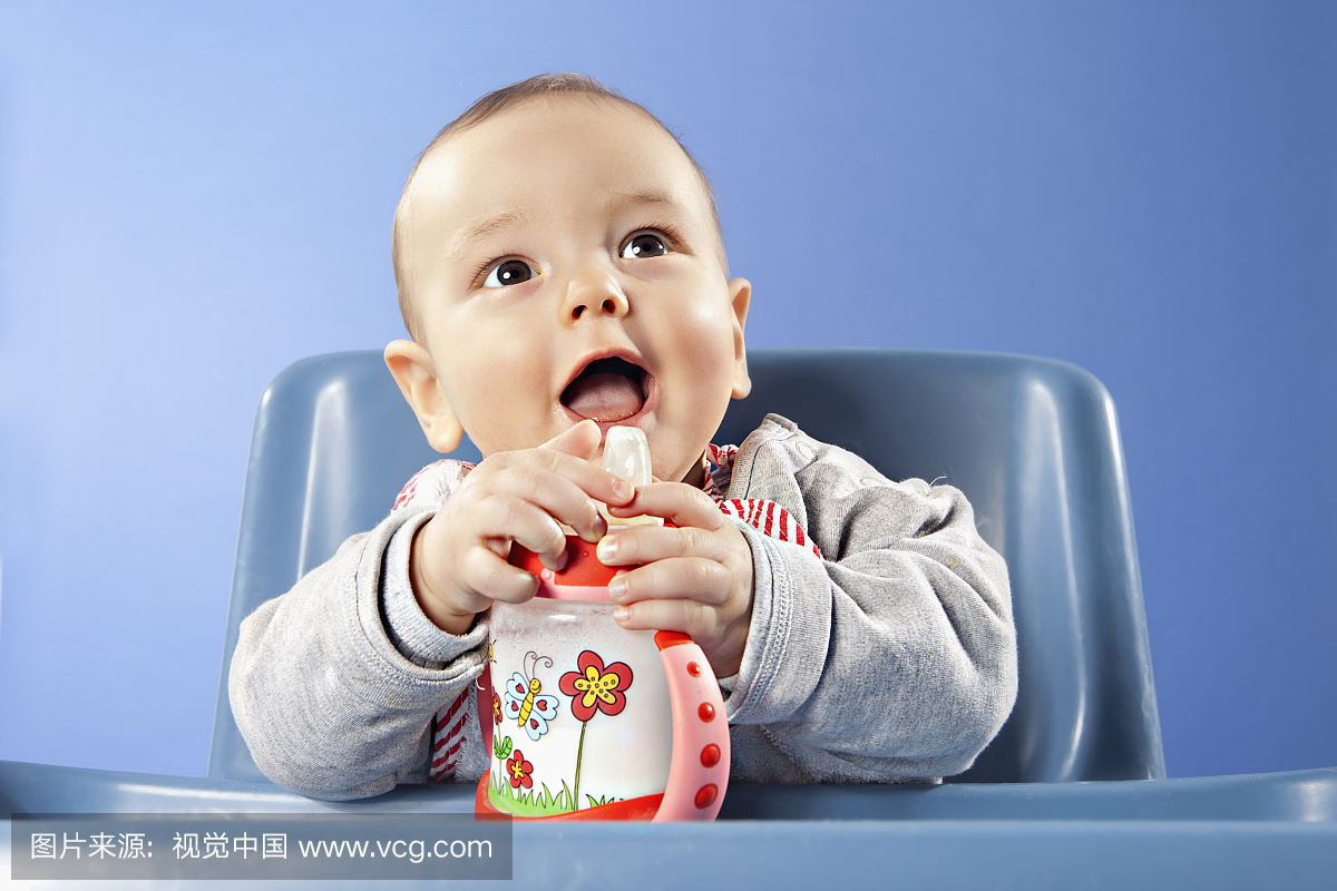 婴儿男孩(6-11个月)抱着婴儿奶瓶
