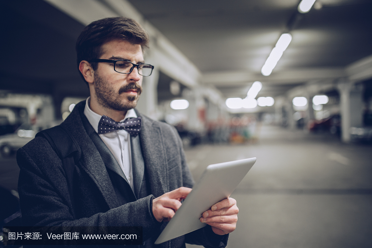 商人在停车场上使用平板电脑