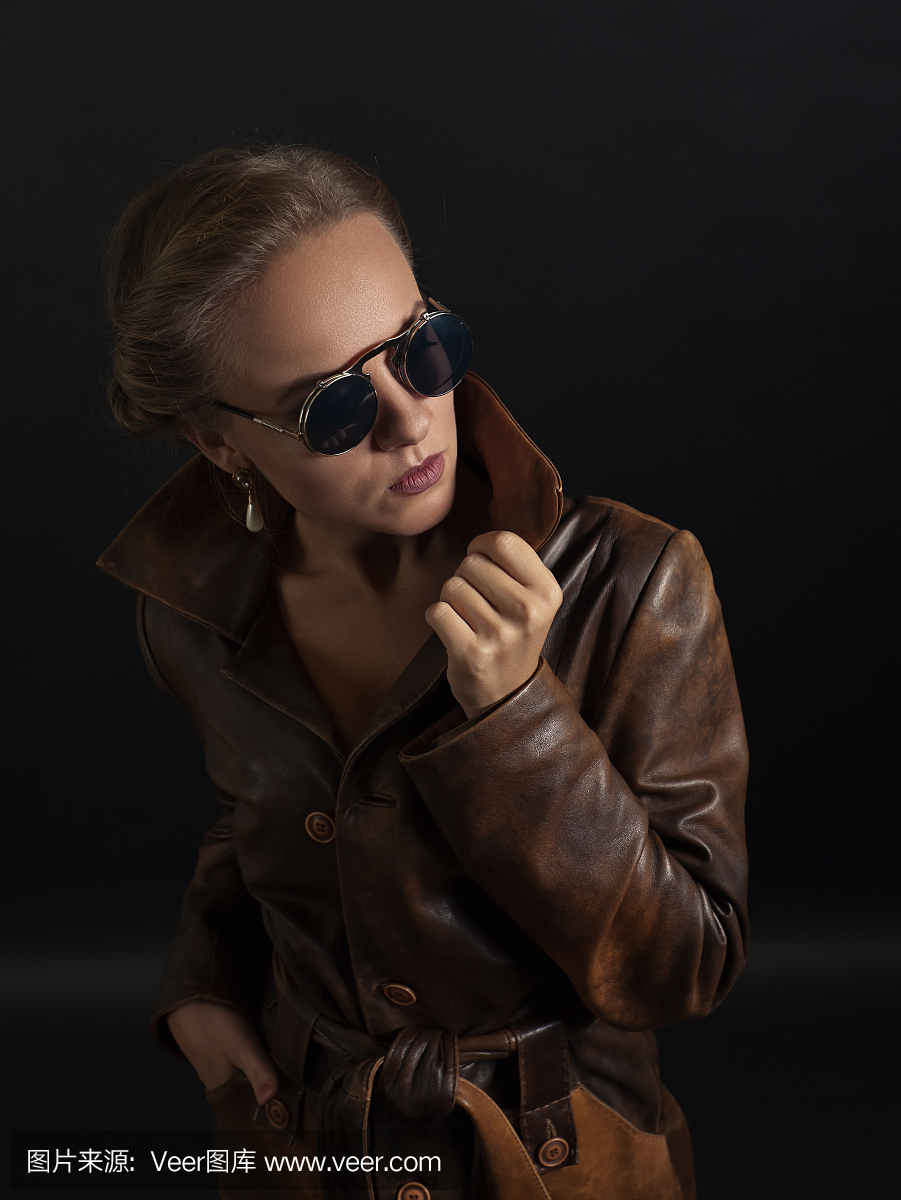 美丽的女人肖像棕色皮大衣和太阳镜