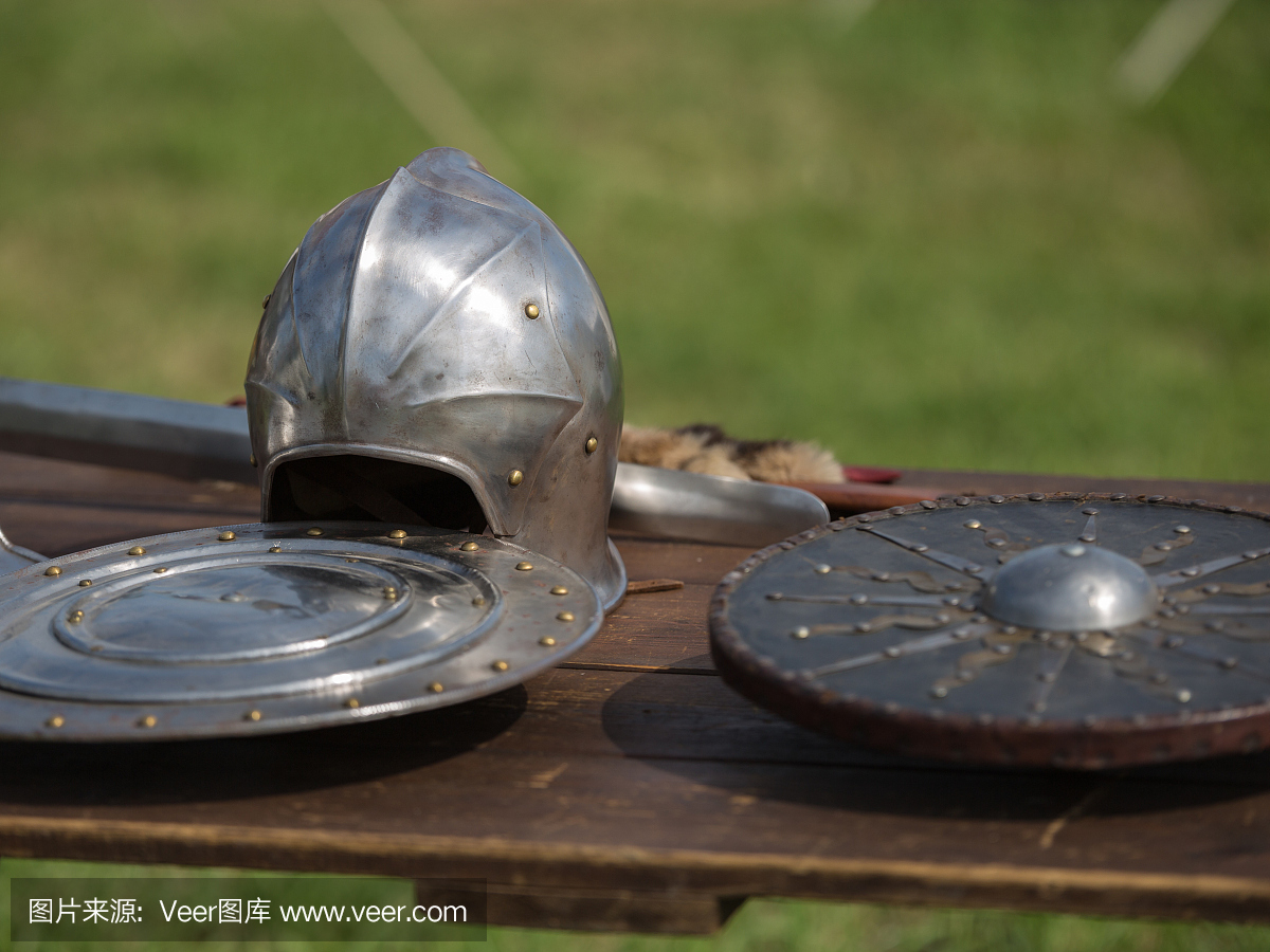 头盔,盾牌和中世纪的金属装甲和武器,户外木制