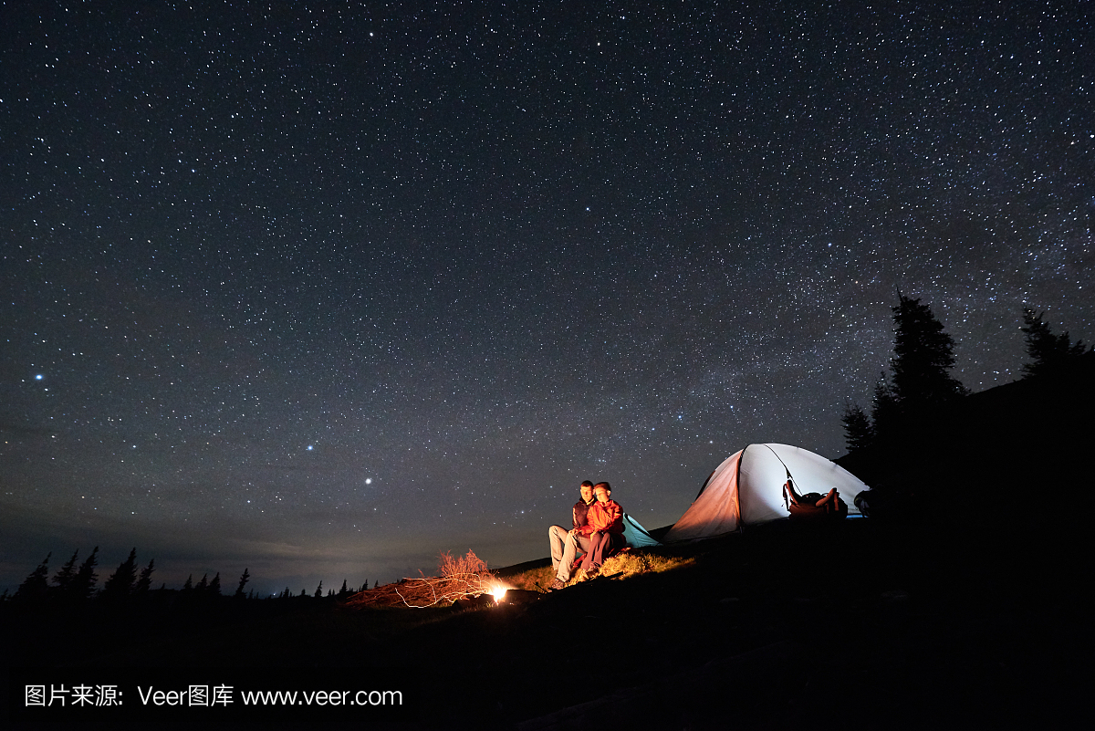 夜露营浪漫的情侣游客在美丽的夜晚星空下的照