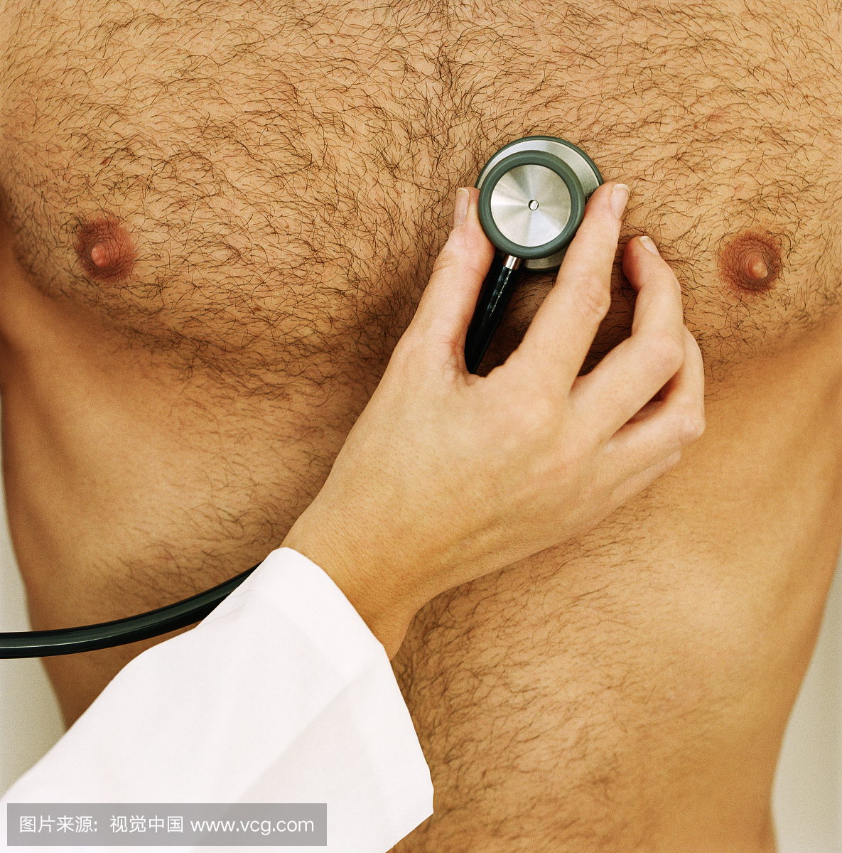 女人拿着听诊器到男人的裸露的胸部,中间部分