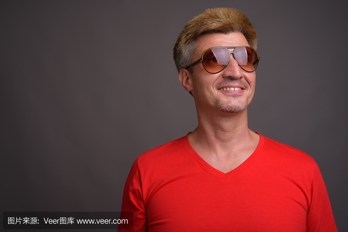 工作室射击的男人与金发穿红色衬衫灰色背景