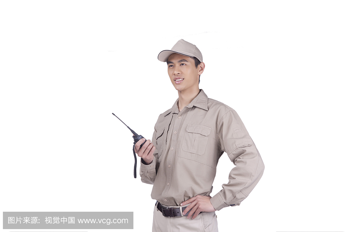 一个穿着工作服用对讲机的青年快递员